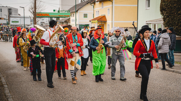 RawmanPictures - Sebastian Schiefermayr | Faschingsumzug Weißkirchen | Karnevalsumzug mit verkleideten Musikern und bunten Kostümen in einer lebendigen Straßenparade.