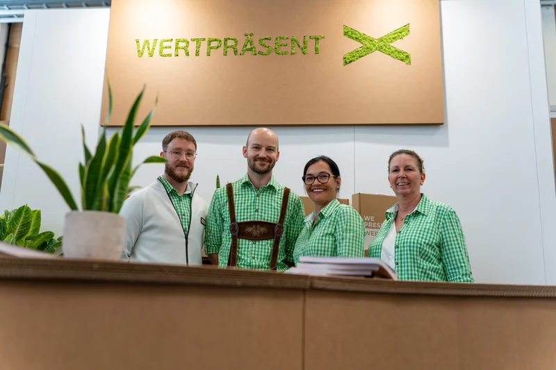 RawmanPictures - Sebastian Schiefermayr | Marke[ding] Wels | Messefotografie Team: Professioneller Auftritt, Teamgeist, grüne Uniformen, Unternehmensrepräsentation.