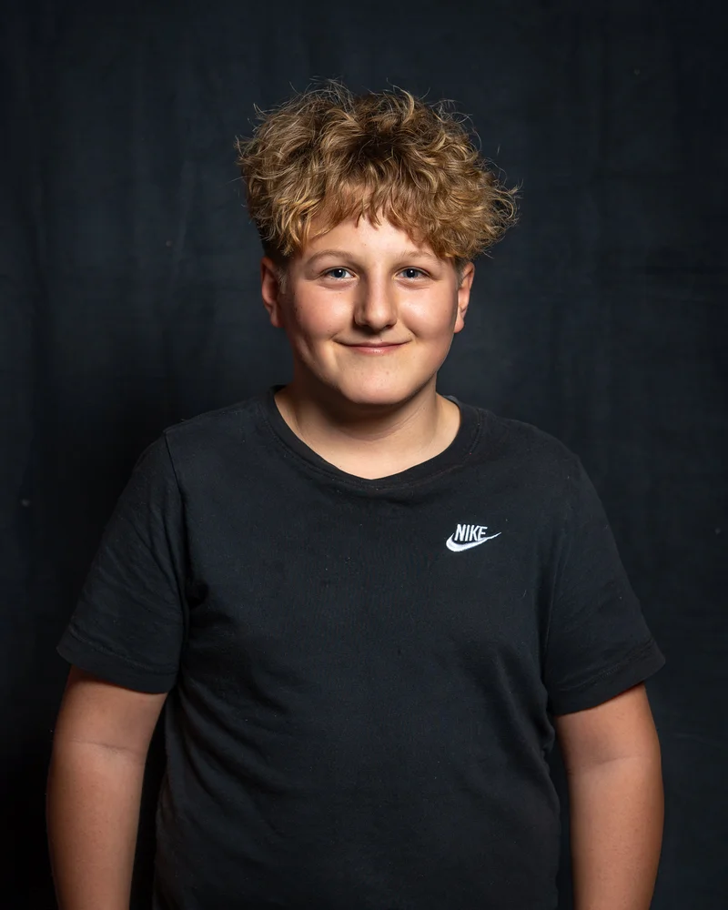 RawmanPictures - Sebastian Schiefermayr | Portrait-Shooting Ozon | Porträt eines lächelnden Jungen vor schwarzem Hintergrund, Studiofotografie.