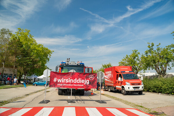 RawmanPictures - Sebastian Schiefermayr | Sommereisdisco | Feuerwehrfahrzeuge und Banner bei sonnigem Event im Freien. Fotografie Stadtveranstaltung.