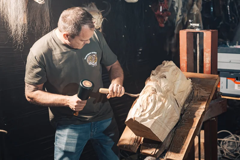 RawmanPictures - Sebastian Schiefermayr | Maskenausstellung | Künstler beim Holzschnitzen in Werkstattumgebung. Handwerk, Kunst und Kreativität zeigen.