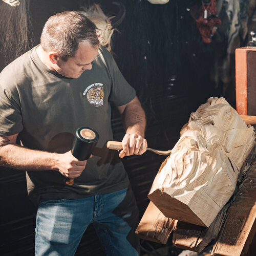 RawmanPictures - Sebastian Schiefermayr | Maskenausstellung | Künstler beim Holzschnitzen in Werkstattumgebung. Handwerk, Kunst und Kreativität zeigen.