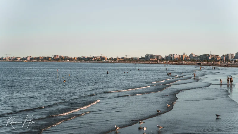 RawmanPictures - Sebastian Schiefermayr | Chioggia 2022 | Küstenfotografie: Sonnenuntergang über dem weiten Strand und sanfte Wellen in der Ferne.