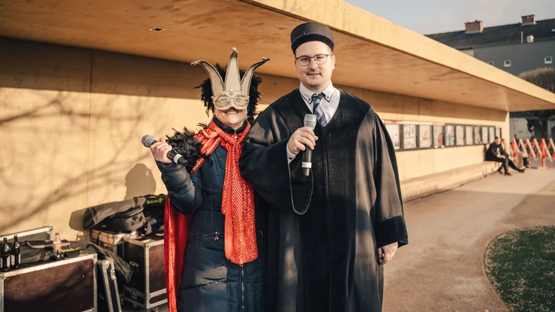 RawmanPictures - Sebastian Schiefermayr | Faschingsumzug Weißkirchen | Zwei kostümierte Personen im Freien, Mikrofone haltend.