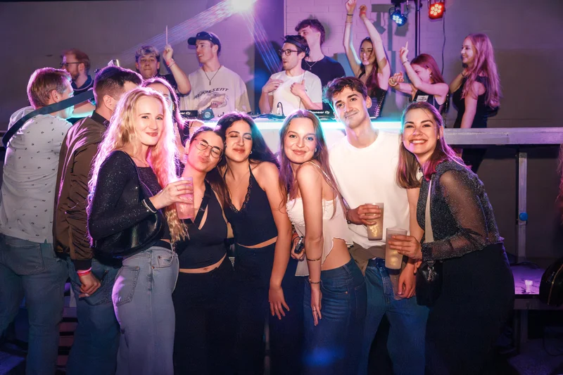 RawmanPictures - Sebastian Schiefermayr | JKU Mensafest | Party-Szene mit Freunden im Nachtclub, Partyfotografie, fröhliche Feier im bunten Licht.