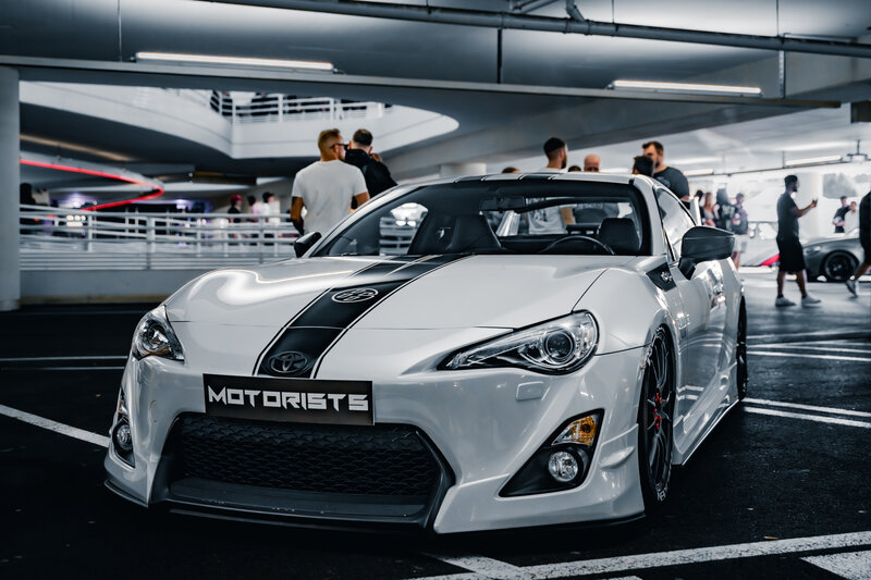 RawmanPictures - Sebastian Schiefermayr | Night of Wheels | Sportwagen-Treff im Parkhaus: Weiße Eleganz & Dynamik. Autotreffen, Tuning, Autofotografie.