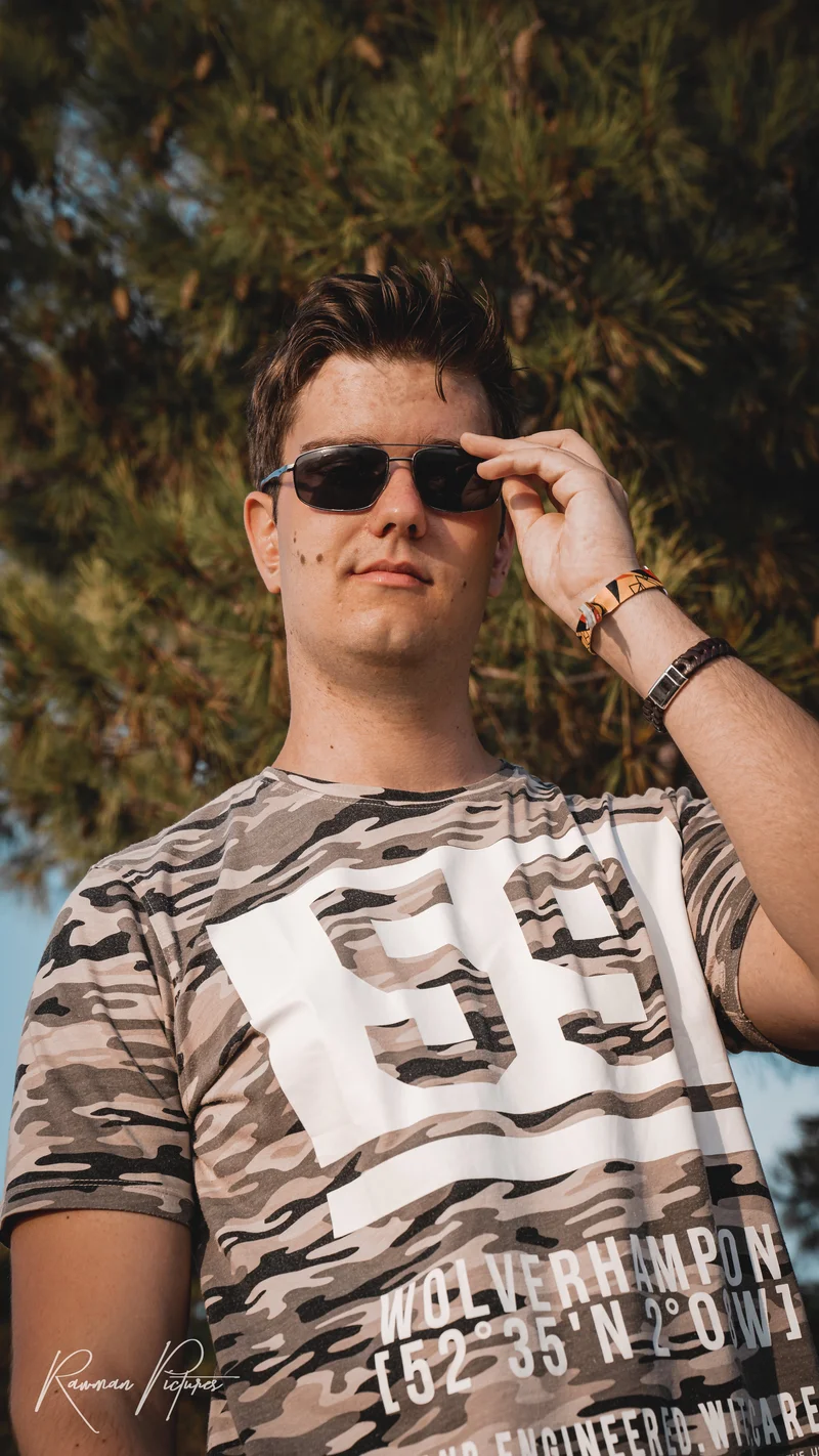 RawmanPictures - Sebastian Schiefermayr | Maturareise Kroatien | Junger Mann im Sonnenlicht mit Sonnenbrille, lässiger Outdoor-Style, Naturfotografie.