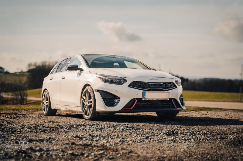 RawmanPictures - Sebastian Schiefermayr | Carshooting Eidenberg | Moderner weißer Sportwagen auf ländlicher Straße unter bewölktem Himmel fotografiert.