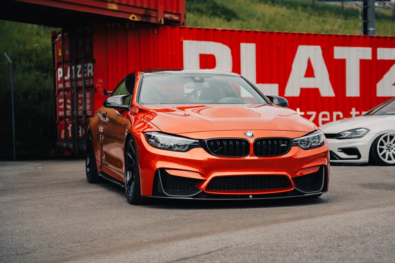 RawmanPictures - Sebastian Schiefermayr | Motortag Salzburg 2025 | Leuchtend rotes Sportauto vor Industriehintergrund, elegantes Design und dynamischer Stil.