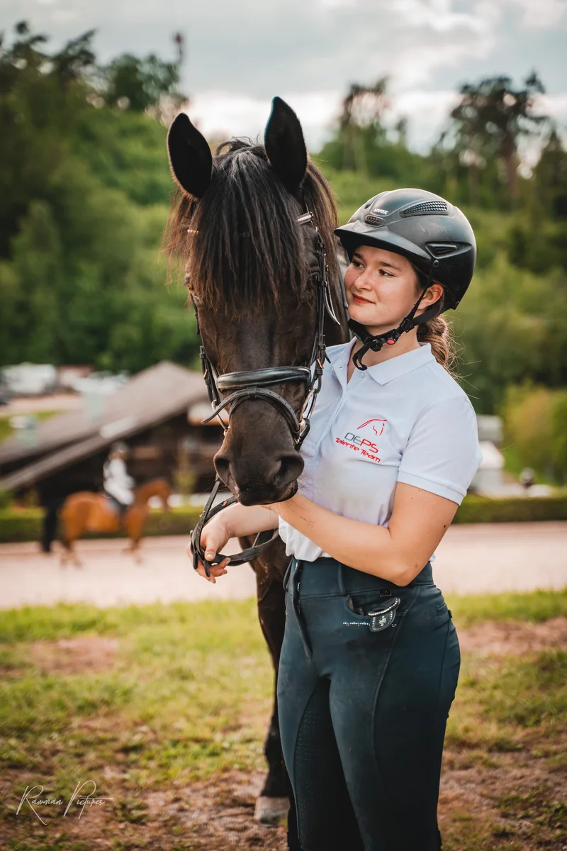 RawmanPictures - Sebastian Schiefermayr | Vielseitigkeits­turnier | Pferdefotografie: Reiterin mit Helm und Pferd in natürlicher Umgebung. Ideal für Reitsportaufnahmen.