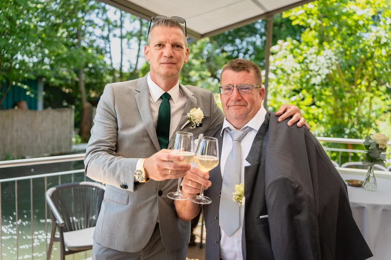 RawmanPictures - Sebastian Schiefermayr | Hochzeit Natalia & Jürgen | Hochzeitsgäste im Freien, elegant gekleidet, mit festlichen Getränken und strahlendem Ambiente.