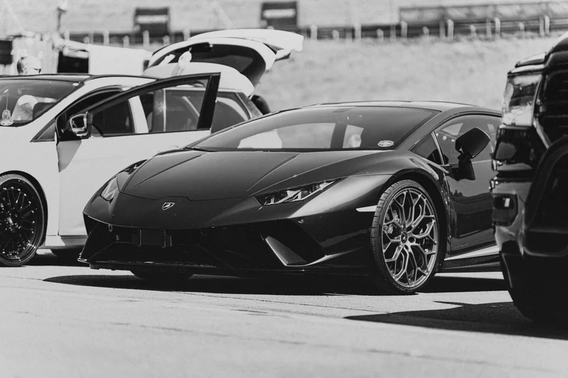 RawmanPictures - Sebastian Schiefermayr | Motortag 2026 | Schwarz-Weiß-Fotografie eines sportlichen Luxusautos auf einem Parkplatz, ideal für Autoliebhaber.