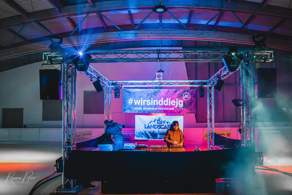 RawmanPictures - Sebastian Schiefermayr | Eisdisco Marchtrenk | DJ legt auf Party auf bunter Bühne auf, dynamische Beleuchtung, Eventfotografie.