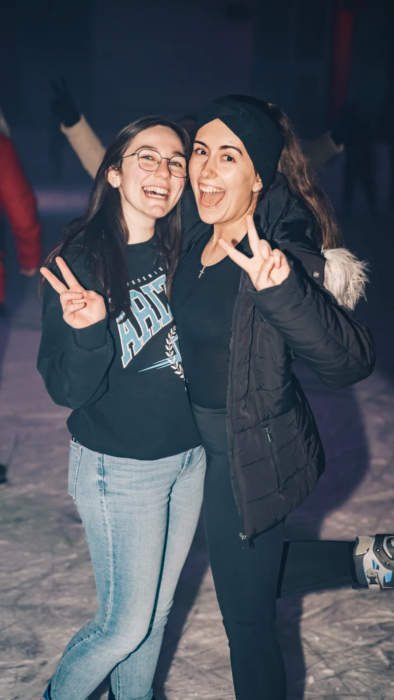 RawmanPictures - Sebastian Schiefermayr | Eisdisco Marchtrenk | Zwei Freunde beim Eislaufen, lächelnd und posierend in Freizeitkleidung. Winterspaß, Freundschaft.