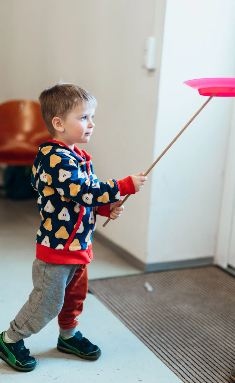 RawmanPictures - Sebastian Schiefermayr | Jonglierworkshop Marchtrenk | Kind spielt mit Jonglierteller, Freizeitspaß, Kinderfotografie, kreative Momente einfangen.