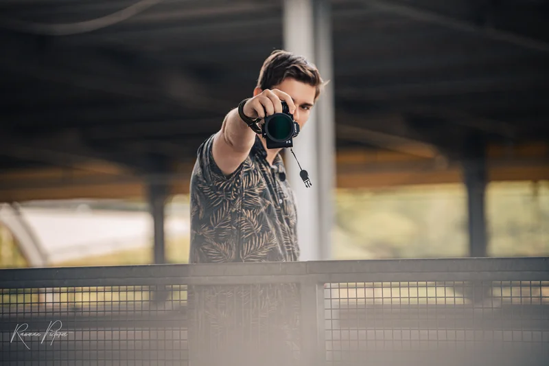 RawmanPictures - Sebastian Schiefermayr | Personal Shooting | Ein Fotograf zielt mit Kamera: Kreativität, Leidenschaft, urbaner Fotografie im Freien festhalten.