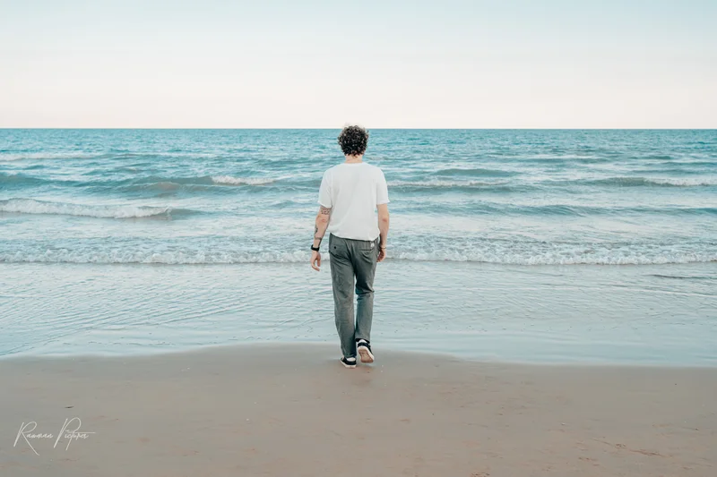 RawmanPictures - Sebastian Schiefermayr | Urlaub Jesolo | Mann am Strand, Meerblick, entspannte Szene, Naturfotografie, Küstenlandschaft, Ruhe und Freiheit.