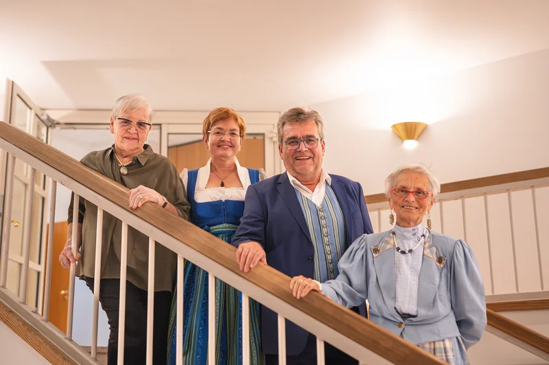 RawmanPictures - Sebastian Schiefermayr | Volkstanzfest | Porträtfotografie von vier Personen in traditioneller, festlicher Kleidung auf einer Treppe.