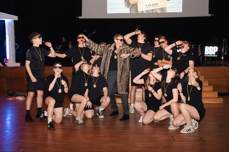 RawmanPictures - Sebastian Schiefermayr | Maturaball HTL1 | Gruppenfoto bei einem Event, auf einer Bühne, alle schwarz gekleidet mit Sonnenbrillen.