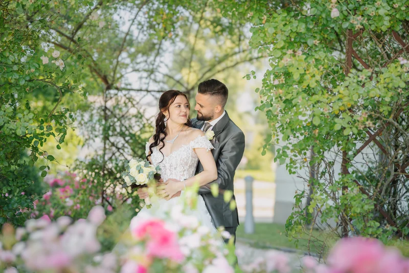 RawmanPictures - Sebastian Schiefermayr | Hochzeit Natalia & Jürgen | Romantische Hochzeitsfotografie im Grünen: Brautpaar umgeben von blühenden Blumen und Natur.