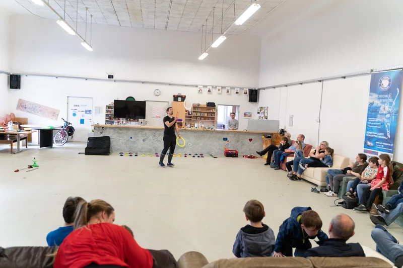 RawmanPictures - Sebastian Schiefermayr | Jonglierworkshop Marchtrenk | Fotografie eines Gemeinschaftsraums mit spielenden Kindern und Erwachsenen. Moderne Innenarchitektur.