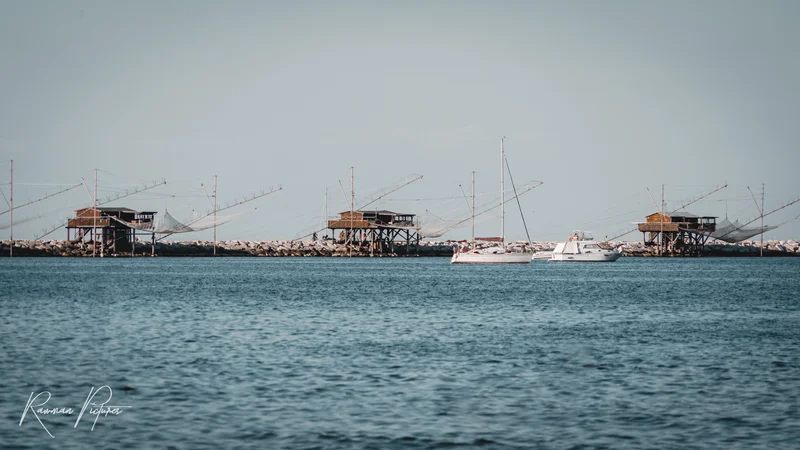 RawmanPictures - Sebastian Schiefermayr | Chioggia 2022 | Küstenfotografie: Fischerhütten und Boote im Meer - ideale Aufnahme für Meeresliebhaber.