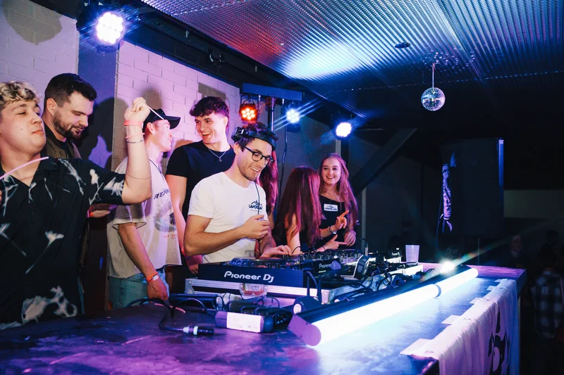 RawmanPictures - Sebastian Schiefermayr | JKU Mensafest | DJ auf Party im Club, energiegeladene Atmosphäre, tanzende Menge, lebendige Nachtfotografie.