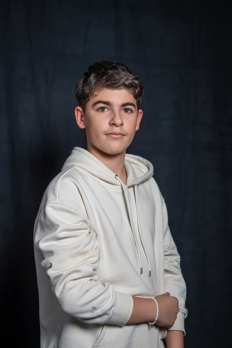 RawmanPictures - Sebastian Schiefermayr | Portrait-Shooting Ozon | Entspanntes Porträt eines Jugendlichen im Hoodie vor dunklem Hintergrund. Studiofotografie.