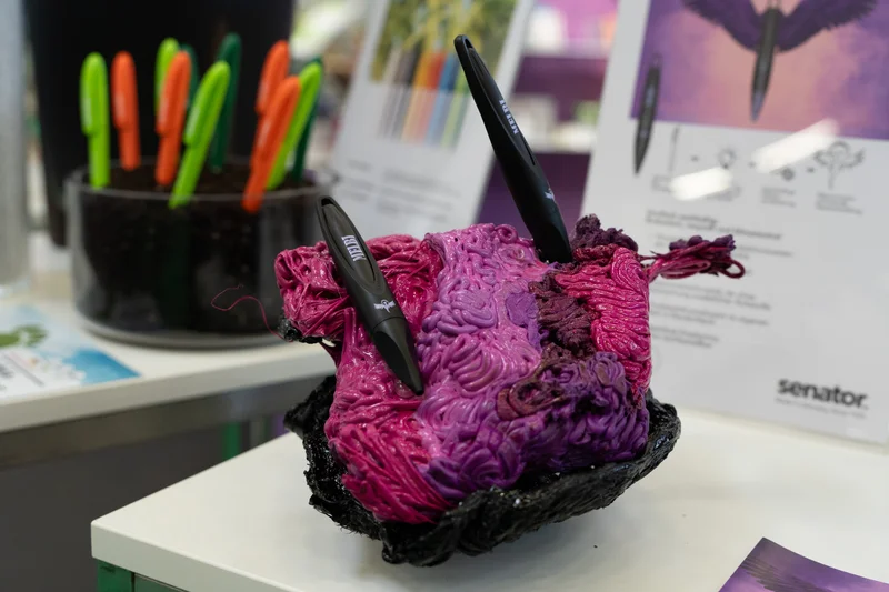 RawmanPictures - Sebastian Schiefermayr | Marke[ding] Wels | Bunte Schreibutensilien auf einer Ausstellung für kreative Bürobedarfsinnovationen.