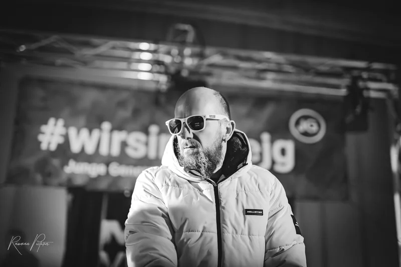 RawmanPictures - Sebastian Schiefermayr | Eisdisco Saisonfinale 2024 | Schwarzweiß-Porträt eines Mannes mit Sonnenbrille auf einer Veranstaltung.