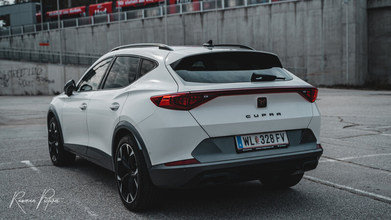 RawmanPictures - Sebastian Schiefermayr | Shooting Fabian K. | Moderner SUV auf urbanem Parkplatz fotografiert, perfekt für Automobil-Fotografie.