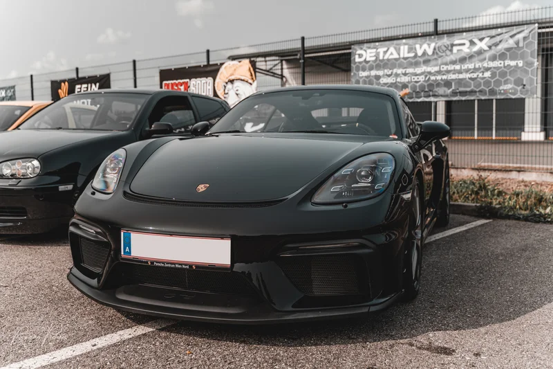 RawmanPictures - Sebastian Schiefermayr | Russnsoda Summer Closing | Luxusauto-Fotografie: Eleganter schwarzer Sportwagen auf einem Parkplatz, perfekte Beleuchtung.