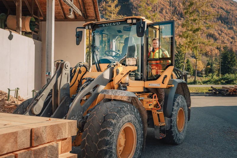 RawmanPictures - Sebastian Schiefermayr | Sägewerk Löberbauer | Radlader transportiert Holzstapel im Sägewerk - effiziente Logistik in der Holzverarbeitung.