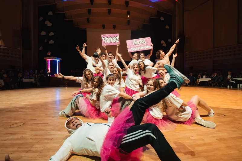 RawmanPictures - Sebastian Schiefermayr | Maturaball HTL1 | Tanzperformance in festlicher Halle, dynamische Gruppenfotografie, kreative Bühnenbeleuchtung.
