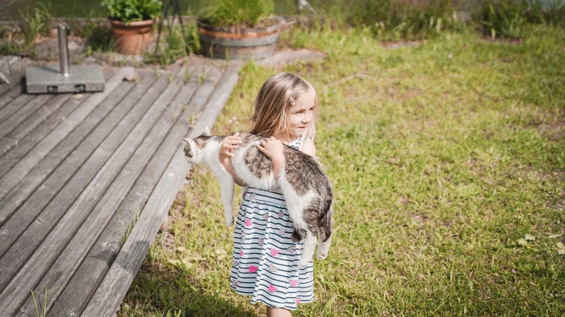 RawmanPictures - Sebastian Schiefermayr | Sägewerk Löberbauer | Kleines Mädchen mit Katze im Garten fotografiert - natürliche Kinder- und Haustierfotografie.