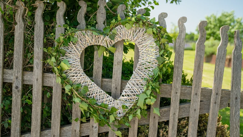 RawmanPictures - Sebastian Schiefermayr | Hochzeit Traude & Gerhard | Herzdeko am Holzzaun: Romantische Gartengestaltung, Naturfotografie, rustikaler Charme.