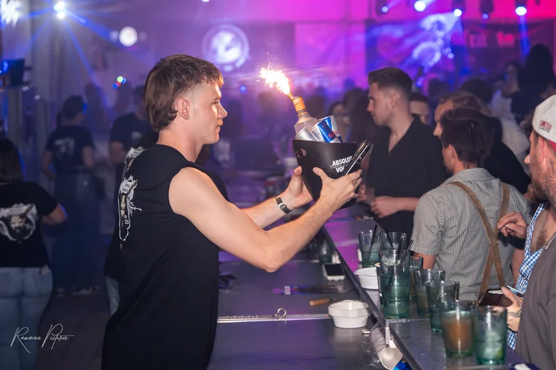 RawmanPictures - Sebastian Schiefermayr | Stadtfest-Marchtrenk  | Bartender serviert brennendes Getränk bei Nacht-Event, Partyfotografie, Eventfotografie.