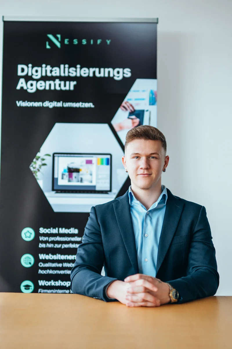 RawmanPictures - Sebastian Schiefermayr | Bussines-Shooting Nessify | Geschäftsmann im Porträt vor Agentur-Poster – Professionelle Business-Fotografie.