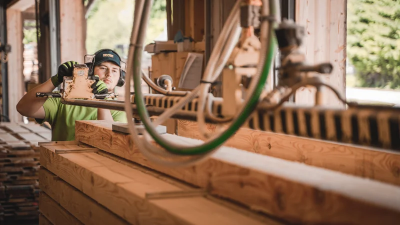 RawmanPictures - Sebastian Schiefermayr | Sägewerk Löberbauer | Handwerker bei der Arbeit an Holzbearbeitungsmaschine in Sägewerk, Holzverarbeitung Fotografie.