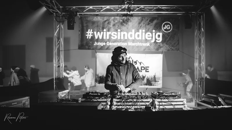 RawmanPictures - Sebastian Schiefermayr | Eisdisco Marchtrenk | DJ bei Veranstaltung in stimmungsvollem Schwarz-Weiß. Partystimmung und Live-Musik-Atmosphäre.
