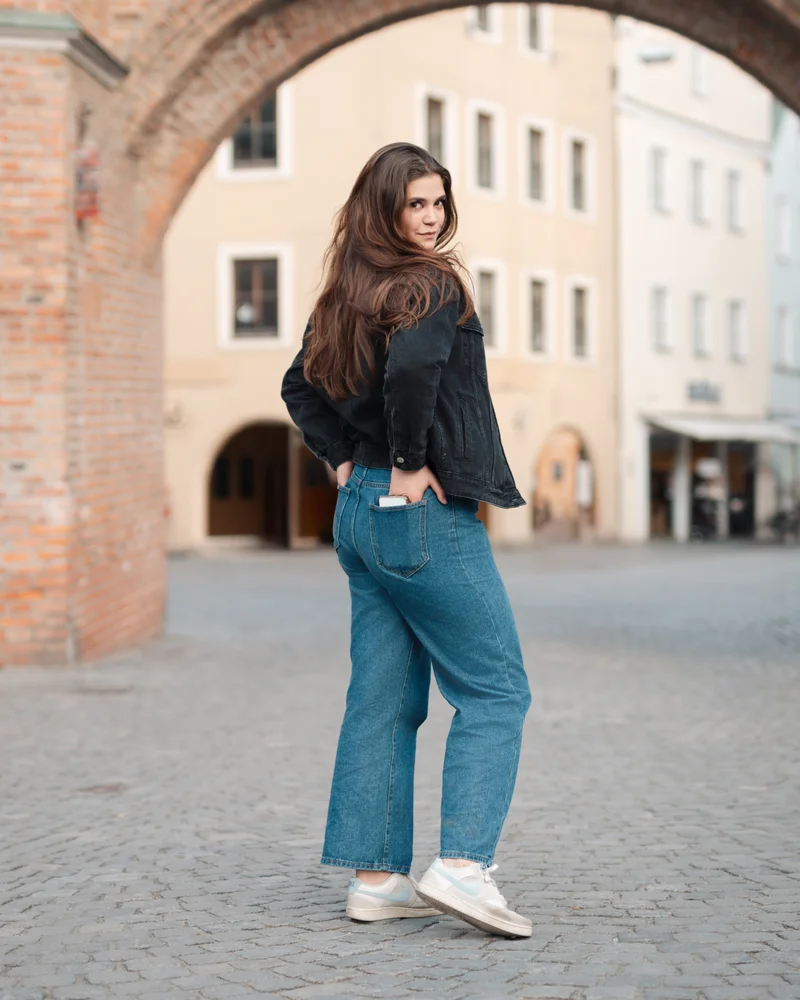 RawmanPictures - Sebastian Schiefermayr | Portraitshooting Vanessa S. | Städtische Modefotografie: Lässige Straßenmode vor historischem Tor. Ideal für Portfolio.