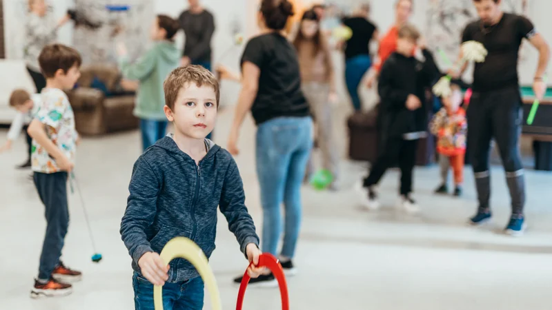 RawmanPictures - Sebastian Schiefermayr | Jonglierworkshop Marchtrenk | Kinder bei Indoor-Spielaktivitäten in lebendigem Gemeinschaftsraum. Eventfotografie für Familien.