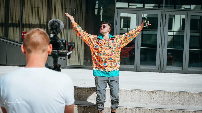 RawmanPictures - Sebastian Schiefermayr | Musikvideodreh "Flinz Asozial" | Mann posiert vor Kamera in farbenfroher Kleidung, Outdoor-Porträtfotografie.