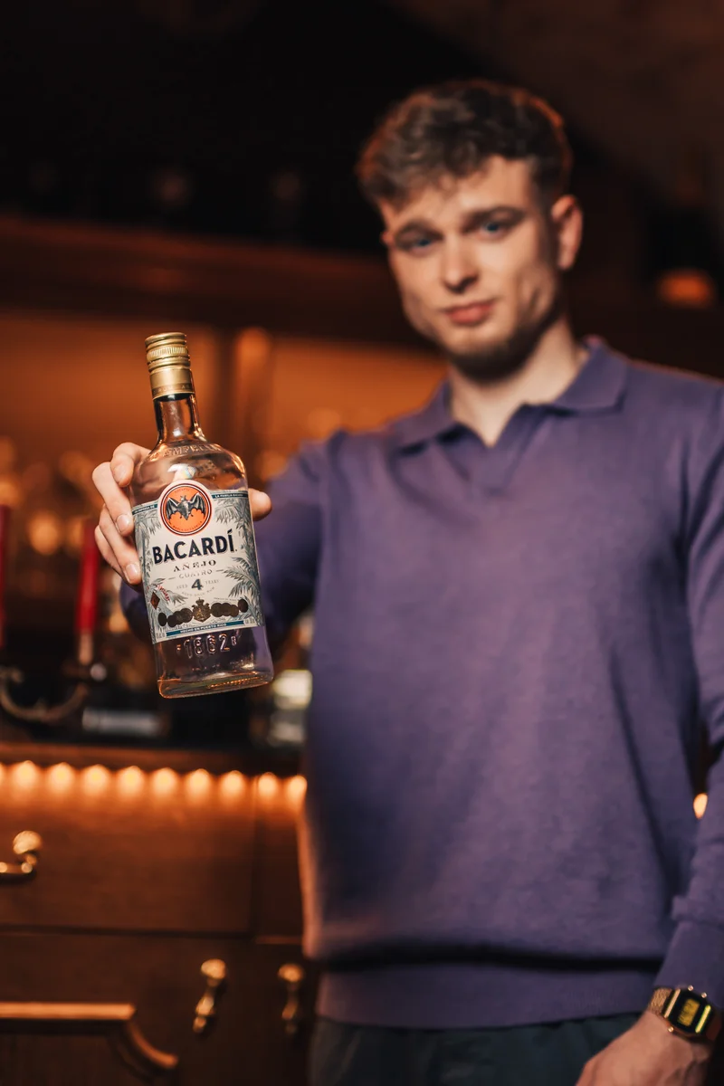 RawmanPictures - Sebastian Schiefermayr | Portraitshooting Kevin F. | Mann im Bar-Ambiente mit Rumflasche – stilvolle Getränkefotografie für Werbung.