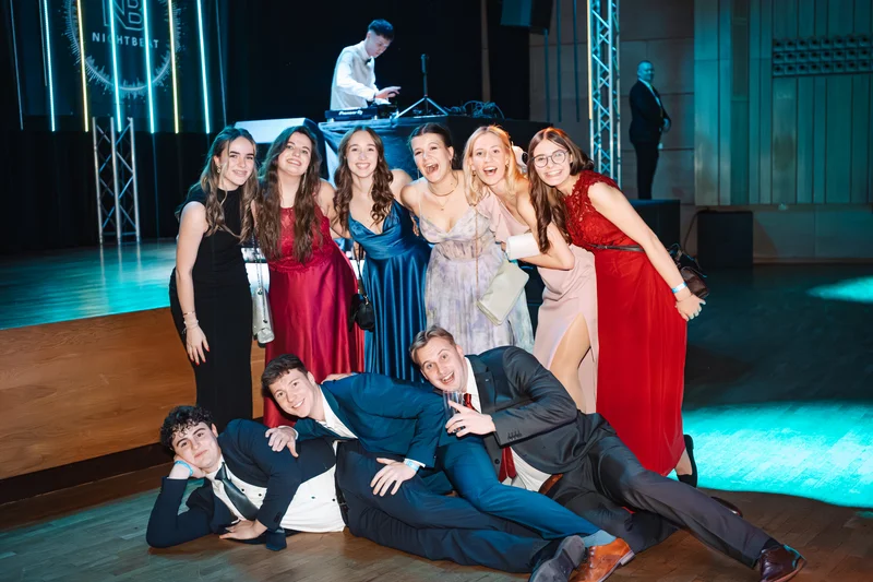 RawmanPictures - Sebastian Schiefermayr | Maturaball HTL1 | Elegant Eventfotografie: Gruppenfoto auf einer stilvollen Feier mit formell gekleideten Gästen.