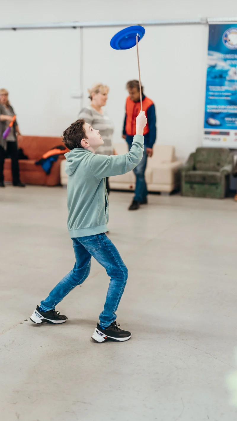 RawmanPictures - Sebastian Schiefermayr | Jonglierworkshop Marchtrenk | Kind jongliert mit Teller, spielerische Fotografie, Event-Aktivität, Dynamik und Spaß.