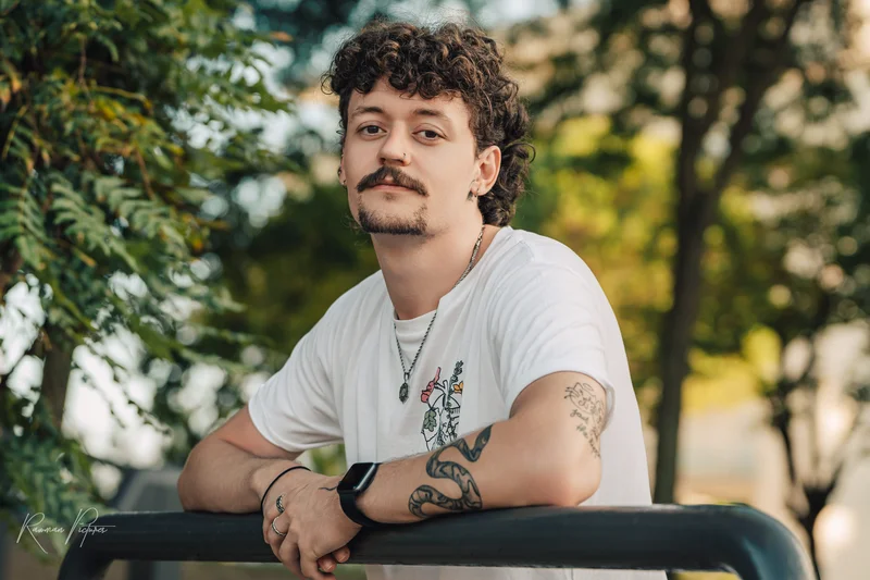 RawmanPictures - Sebastian Schiefermayr | Urlaub Jesolo | Porträt eines entspannten Mannes im Freien mit natürlichem Licht und Tattoo-Designs.