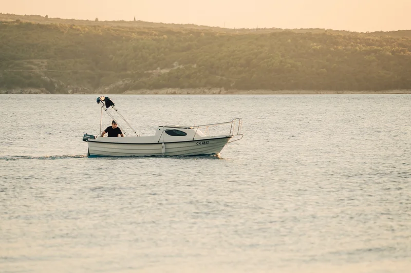 RawmanPictures - Sebastian Schiefermayr | Content Trip: Crikvenica 2025 | Fischerboot bei Sonnenuntergang auf ruhigem Meer, Landschaftsfotografie, maritime Idylle.