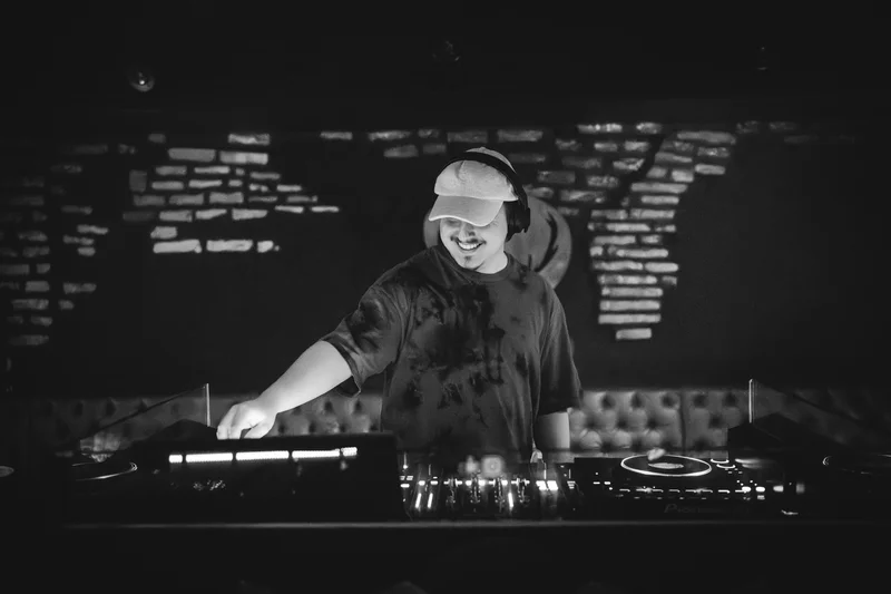 RawmanPictures - Sebastian Schiefermayr | AMP'D Drum & Bass | DJ bei Nacht-Performance, stilvolle Schwarz-Weiß-Aufnahme, Musikfotografie, Clubszene。