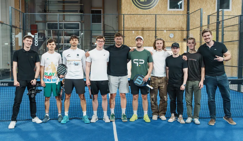 RawmanPictures - Sebastian Schiefermayr | Padelbase Videodreh | Gruppe von Padelspielern auf einem blauen Platz stehend. Teamgeist im Indoor-Sportzentrum.